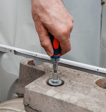 Handyman repairing a washing machine. The hands of a man repair a washing machine.